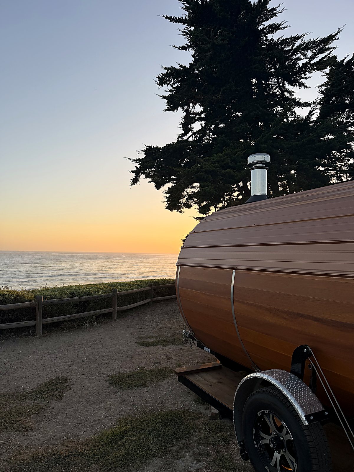 The sun going down over the Pacific from a bluff-top pullout along the coast.