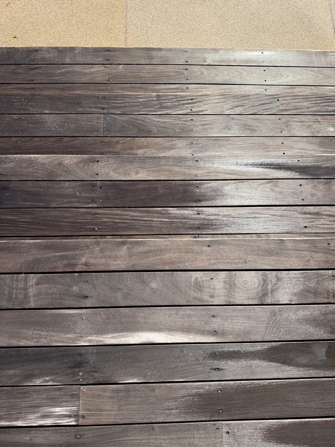 Before: the same style of deck boards weathered grey by sun exposure.