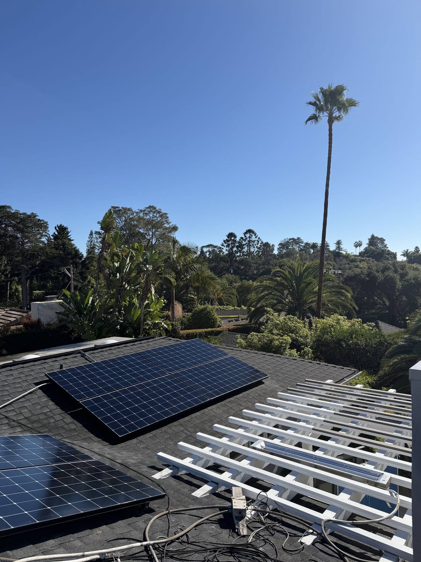 Solar panels on a tile roof above the hillside homes of Santa Barbara.